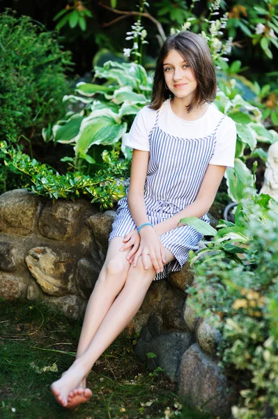 Mooi lachend tienermeisje in blauwe blouse, tegen groen van zomerpark. — Stockfoto