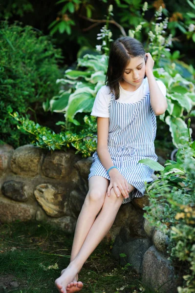 Mooi lachend tienermeisje in blauwe blouse, tegen groen van zomerpark. — Stockfoto