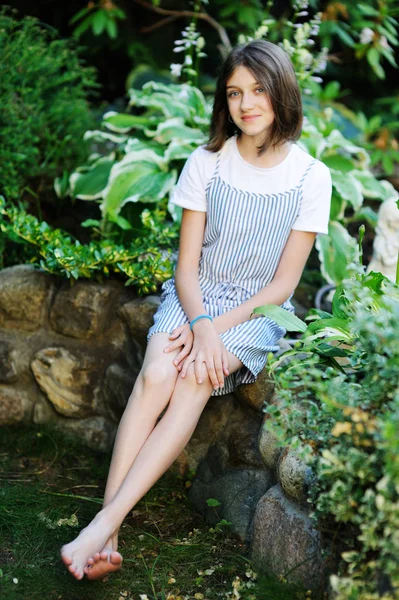 Gyönyörű mosolygós tini lány kék blúzban, szemben a zöld nyári park. — Stock Fotó