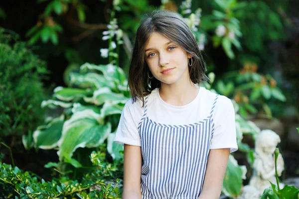 Mooi lachend tienermeisje in blauwe blouse, tegen groen van zomerpark. — Stockfoto