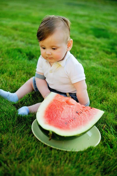 Vacker liten pojke äter mogen vattenmelon på naturen — Stockfoto