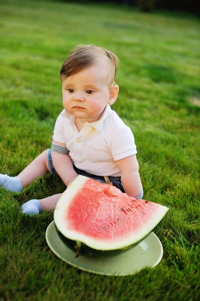 Hermoso niño come sandía madura en la naturaleza —  Fotos de Stock