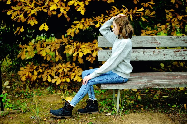 Teenagermädchen sitzt an der Eiche. — Stockfoto