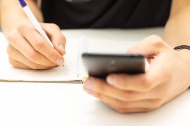 Öğrenci kullanın cep telefonu dizüstü network.writing üzerinden bilgi arama. 