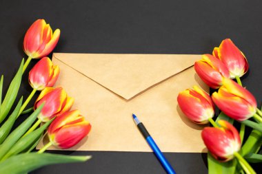 Zarf veya mektup ve lale tebrik anne veya kadın günü için siyah arka plan üzerine