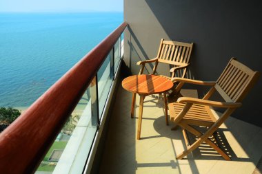 Balkon ve Teras bir otelin sahilde boş ahşap sandalye. Okyanus görmek.