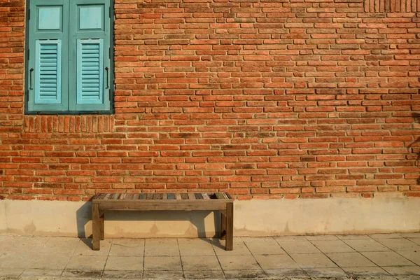 Παλαιά ξύλινη καρέκλα ενάντια σε έναν τοίχο από τούβλα grungy με ξύλινα blu — Φωτογραφία Αρχείου