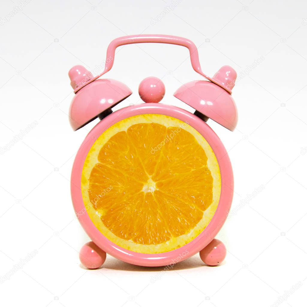 Creative layout fresh of orange slice on alarm clock, minimal co