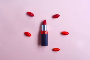 Pastel arka planda izole tatlı kırmızı meyve ile kırmızı ruj,