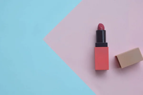 Roter Lippenstift auf pastellfarbenem Hintergrund, minimales Make-up — Stockfoto