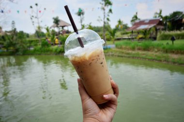 Bir kafede bir bardak buzlu kahve tutan el