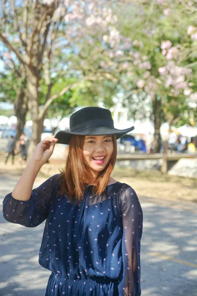 Beautiful young asian woman with blooming cherry  in a park blos — Stock Photo, Image