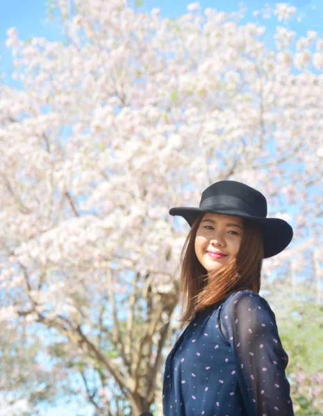 Krásná mladá asijská žena s kvetoucí třešničkou v parku — Stock fotografie
