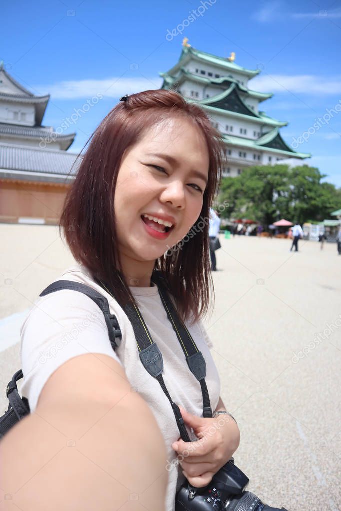 Travel asian woman taking selfie photo with Nagoya castle during