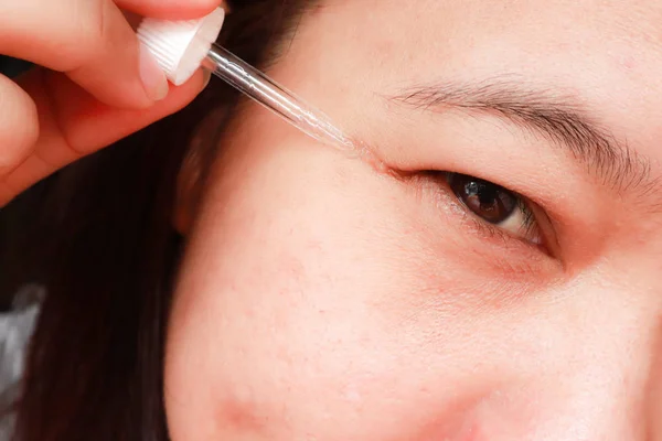 Mujer asiática aplicando suero hidratante anti-envejecimiento a la vista — Foto de Stock
