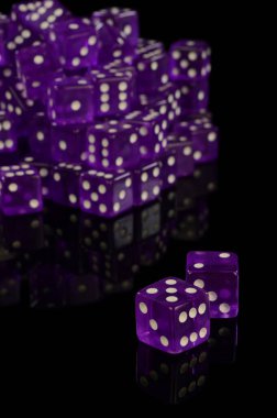 Siyah yansıtıcı bir yüzey üzerinde kullanılmamış yeni bir Casino sınıfı zar yığını.