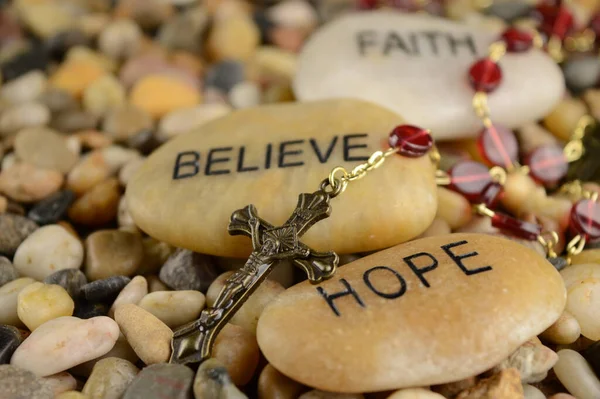イエス キリストの信仰に意味をもたらすためにロザリオを持つ言葉の石 — ストック写真