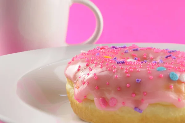 ピンクの背景に焼きたてのドーナツとコーヒーのローアングルのクローズアップ — ストック写真