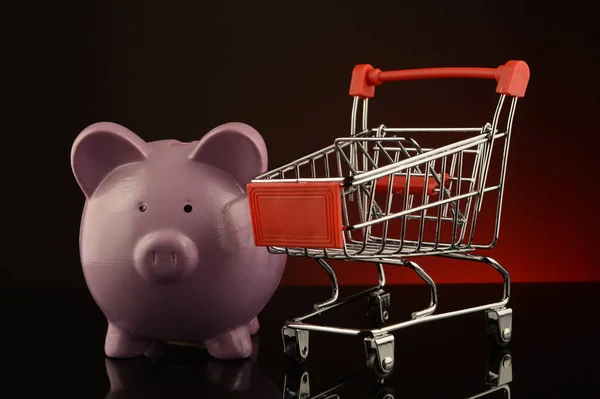販売の概念を説明するために貯金箱とショッピングカート — ストック写真