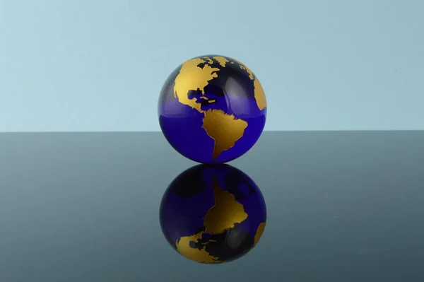 Sebuah Bola Kristal Biru Dari Bumi Dengan Latar Belakang Reflektif — Stok Foto