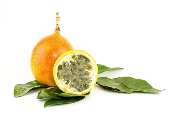 Granadilla entier et demi de fruits doux remplissage aigre rafraîchit sur les feuilles vertes — Photo