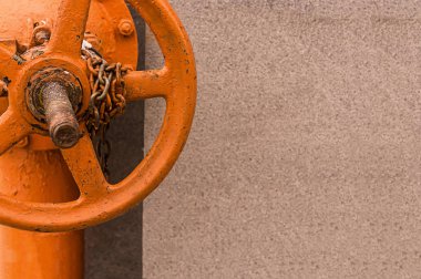 Beton boru temel closeup kopya alanı üzerinde monteli zinciri ile büyük valf ile parlak turuncu boya boyalı