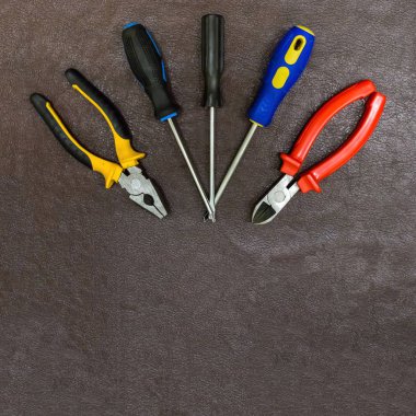 kopya spase temel tasarım bir koyu kahverengi zemin üzerine tornavida pense pense ile plastik parlak kalem koruma ayarla