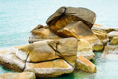 Set taş büyük kahverengi yıpranmış eski deniz kabuklarını arka planını, masmavi okyanus kapalı kırık