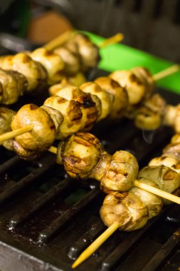 iştah açıcı bütün petrol ızgara arka plan temel menü tasarımı üzerinde ahşap sopa yığında mantar