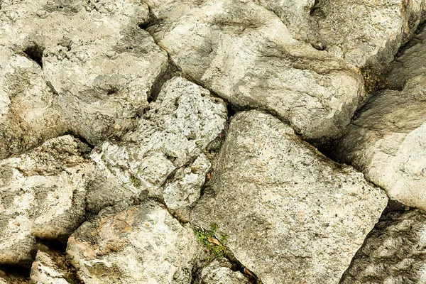 pile of stones gray beige part of the hill rock weathered uneven old surface