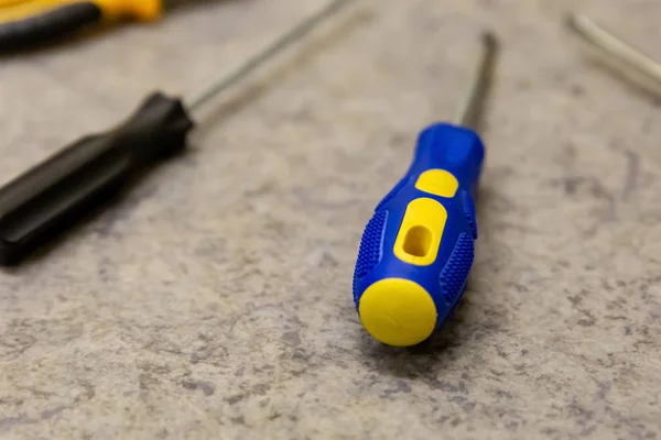 Chave de fenda amarelo azul reparação casa mestre fixadores fixação fim borracha alça proteção — Fotografia de Stock