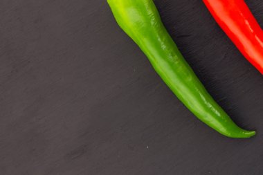 siyah bir arka plan üzerinde bir sebze dekorasyon mutfak tasarımı keskin biber biber kırmızı yeşil biber parçası, kayrak temel kopya alanı