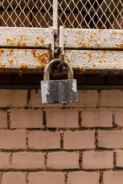 Urban design grunge style hinged metal hinged lock weathered choppy paint gray on brick wall background — Stock Photo, Image