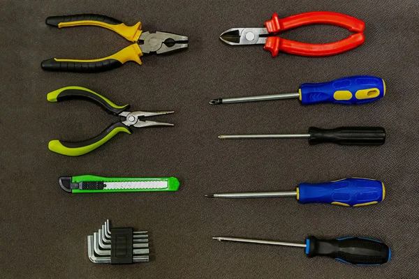 Készlet eszközök gumi fogantyú csavarhúzó kék sárga fogó L-alakú kulcs kés vágó fogó — Stock Fotó