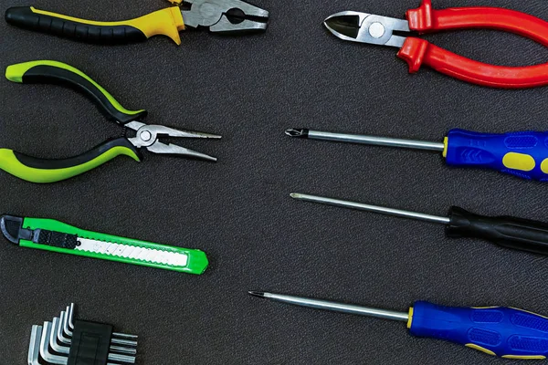 Set destornillador fila simétrico verde cuchillo construcción alicates plástico sobre un fondo oscuro base diseño —  Fotos de Stock