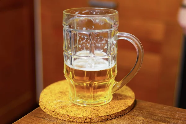 Boccale birra campo d'oro su un tavolo di legno su uno sfondo sfocato pub di design. Mezza tazza di birra — Foto Stock