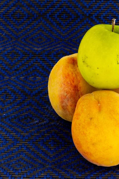 Par de melocotones maduros manzana verde sobre un fondo azul delicioso conjunto. postre de ensalada de fruta base — Foto de Stock