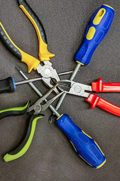 Tres destornilladores azul conjunto de goma alicates rojo amarillo verde macro herramientas de reparación de fondo —  Fotos de Stock