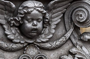 Çek Cumhuriyeti Prag Mart 2017. Bronz süsler eski heykel cupid melek baş bir monogram ile yıpranmış eski bir lamba tüp parçası bırakır.