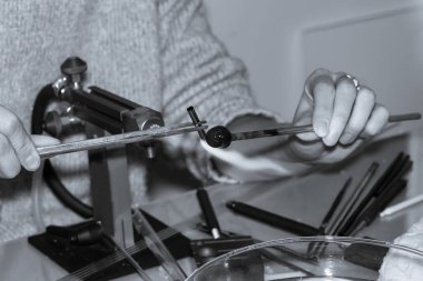 cam oyuncak kıvırcık el cam üfleyici bir gaz brülör üzerinde ısıtır monokrom tasarım manuel üretim