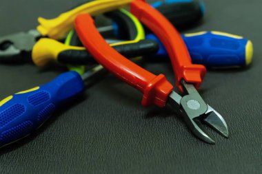 kahverengi arka plan üzerinde mavi tornavida kauçuk kırmızı nippers endüstriyel grunge arka plan tabanı
