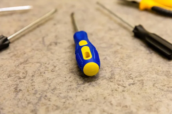 Amarillo azul destornillador conjunto herramientas diseño trabajador reparación tornillos de fijación fondo —  Fotos de Stock
