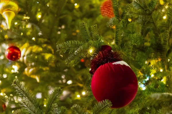 Juguete rojo decoración de Navidad cubierta de nieve en la base de diseño de primer plano del árbol — Foto de Stock