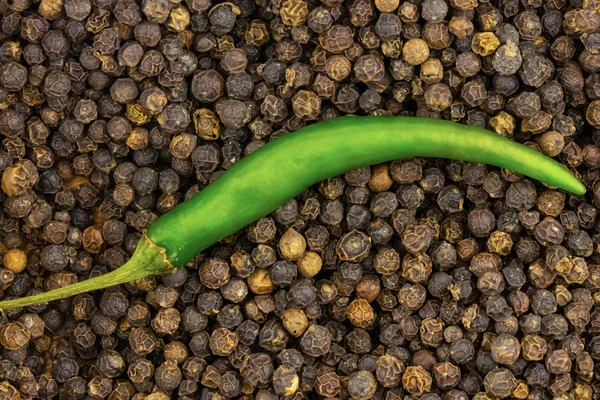 Verde pimienta picante vaina curvo primer plano fondo pimienta granos negro fragante — Foto de Stock