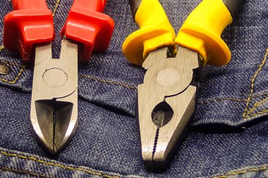 çift kesme pliers sarı kırmızı metal kafa inşaat aracı koyu mavi arka plan üzerinde yakın