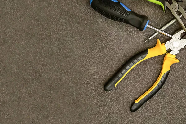 Arbeitswerkzeug gelb schwarz Zangen Schraubenzieher Möbel Reparatur Master Kopierraum dunklen Hintergrund — Stockfoto