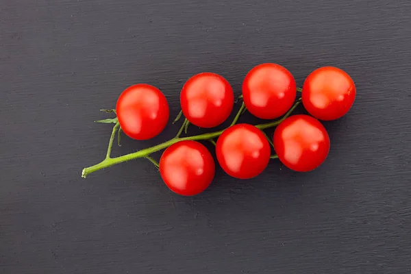Kiraz üst görünüm yeşil dal domates kırmızı mini siyah arka plan — Stok fotoğraf