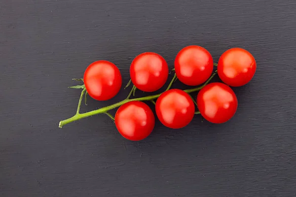 Cerise vue de dessus branche verte tomate rouge mini fond noir — Photo