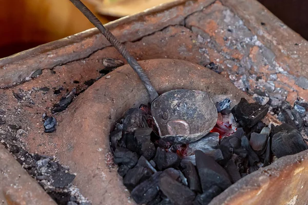 Рог из жидкого металла, изготовление картриджей вручную, традиционное производство горящих углей — стоковое фото
