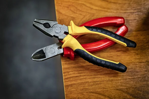 set pliers pliers koyu kolları plastik kenar ahşap masa bir mühendis